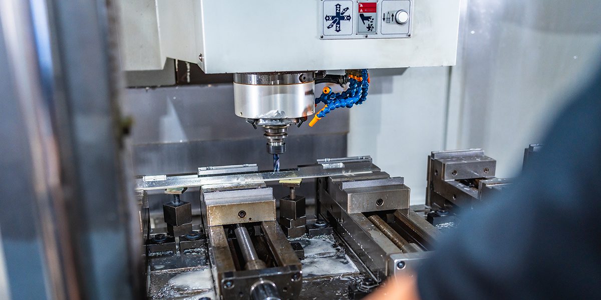 Man working with milling machine in cnc factory | Hibshman Man working with milling machine in cnc factory